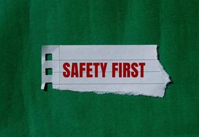 Safety first message written on ripped torn paper with green background. Conceptual safety first symbol. Copy space. photo