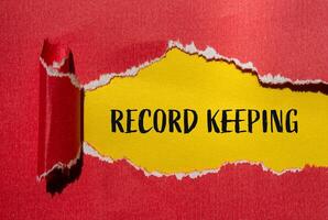 Record keeping message written on ripped torn red paper with yellow background. Conceptual record keeping symbol. Copy space. photo