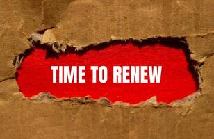 Time to renew message written on torn cardboard paper with red background. Conceptual time to renew symbol. Copy space. photo