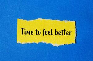 Time to feel better message written on ripped yellow torn paper piece with blue background. Conceptual time to feel better symbol. Copy space. photo