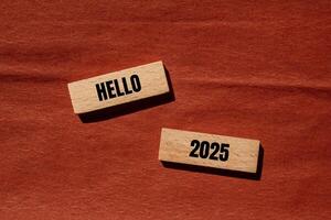 Hello 2025 message written on wooden blocks with brown background. Conceptual hello 2025 symbol. Copy space. photo