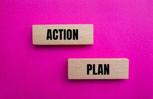 Action plan message written on wooden blocks with pink background. Conceptual action plan symbol. Copy space. photo