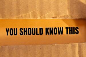 You should know this message written on ripped torn cardboard paper with orange background. Conceptual you should know this symbol. Copy space. photo