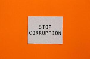 Stop corruption message written on paper piece with orange background. Conceptual stop corruption symbol. Copy space. photo