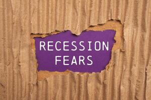 Recession fears message written on ripped torn cardboard paper on purplebackground. Conceptual recession fears symbol. Copy space. photo