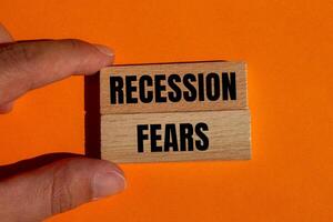 Recession fears message written on wooden blocks on orange background. Conceptual recession fears symbol. Copy space. photo