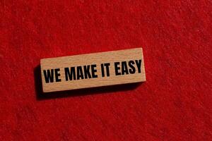 We make it easy message written on wooden block with red felt background. Conceptual we make it easy symbol. Copy space. photo