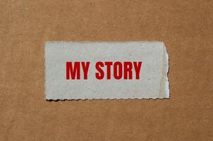 My story message written on ripped torn paper piece with cardboard background. Conceptual my story symbol. Copy space. photo