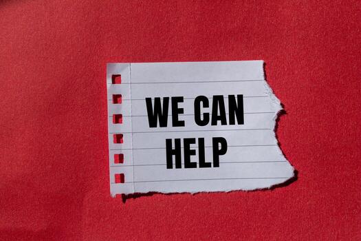 We can help message written on ripped torn paper with red background. Conceptual we can help symbol. Copy space. photo