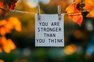 You are stronger than you think message written on paper hung with clothespins photo