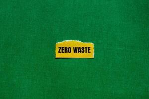 Zero waste message written on ripped torn yellow paper piece with green background. Conceptual zero waste symbol. Copy space. photo