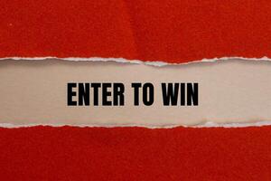 Enter to win message written on ripped red torn paper with beige background. Conceptual enter to win symbol. Copy space. photo