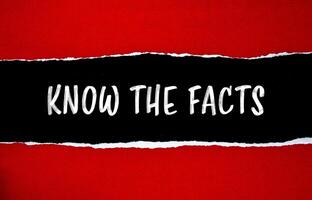 Know the facts message written on ripped torn red paper with black background. Conceptual know the facts symbol. Copy space. photo