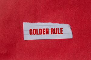 Golden rule message written on ripped torn paper piece with red background. Conceptual golden rule symbol. Copy space. photo