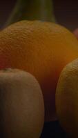 un colección de vistoso agrios frutas desplegado hermosamente en un oscuro antecedentes video