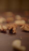 A closeup view of an assortment of mixed nuts artistically displayed on a wooden surface video