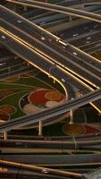 Aerial view of a vibrant urban highway intersection with colorful landscaping and traffic video