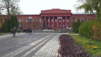 Visitors stroll through the beautiful grounds of Taras Shevchenko National University of Kyiv, enjoying the vibrant spring flowers and historic architecture on a pleasant day. video