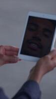 A closeup view of a face displayed on a tablet screen set in a contemporary modern environment video