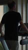 A Man Engaged in Exercising on a Treadmill While in a Gym Environment and Setting Up video
