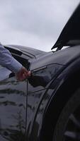 A Sleek and Stylish Black Car Positioned Gracefully Beneath a Dramatic Cloudy Sky video