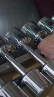 A closeup view of Chrome Dumbbells displayed beautifully in a modern Fitness Studio setting video