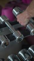 A detailed closeup view of dumbbells displayed in a stylish and contemporary gym setting video