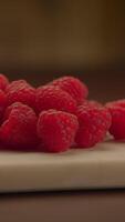 Freshly picked and vibrant Raspberries beautifully arranged on a wooden Cutting Board surface video