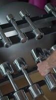 A wellorganized row of various dumbbells displayed prominently in a modern gym facility video