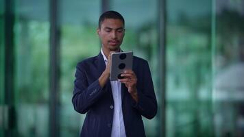 A Young Man Deeply Engaged with His Mobile Device While in a Modern Urban Environment video