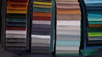 Fabric and textiles samples in a factory shop or store. Different colors and patterns on the market video