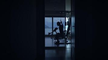 A person working out in a dim room, enjoying a stunning scenic view through the window video
