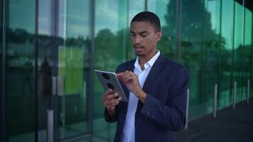 A young professional utilizing a digital tablet while enjoying the outdoors in an urban environment video
