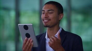 A young professional is engaging actively with a tablet while in a modern and dynamic environment video