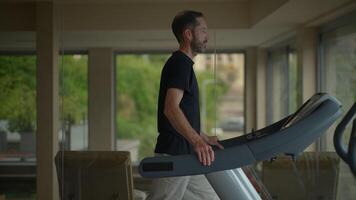 A man is exercising diligently on an elliptical machine in a contemporary gym setting video