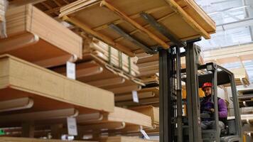 Warehouse worker driver in uniform loading lumber by forklift stacker loader video