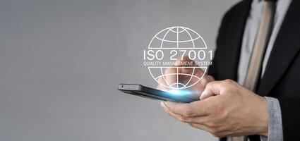 Businessman holding a tablet and showing a symbol ISO 2700, Information security management standard system photo