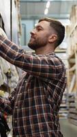 Electrician sells electrical cables in a hardware store. Vertical video