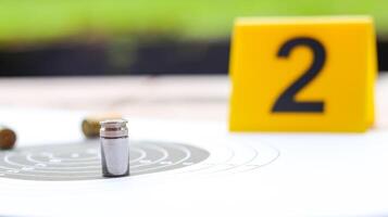 An empty bullet casing on a shooting target background, with a blurred black number 2 behind it, symbolizing crime investigation and forensic analysis. photo