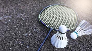 Badminton shuttlecocks with rackets on dark dirt background symbolizing the spirit of exercise and global competition the essence of athleticism and the pursuit of excellence in the sport. photo
