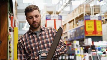 A man is buying new chainsaw in a tool store video