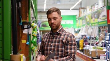 A man in a hardware store chooses a new axe video