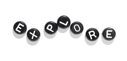 Explore concept using alphabet beads on white background for creativity and learning photo