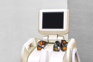 Modern laser hair removal machine with protective goggles in a beauty clinic setting. photo