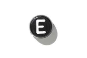 Close-up of vintage typewriter key with letter e on white background featuring shadow and texture photo