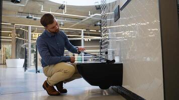 A man choosing elite black ceramic toilet bowl for WC room at plumbing store video