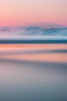 A long exposure photograph of the ocean at sunset photo