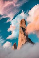 Tall Rock Formations Emerging from Colorful Clouds. photo