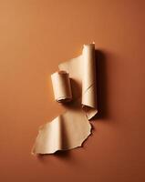 A tan piece of paper with an uneven edge is torn and rolled to create a frame on an orange background. photo
