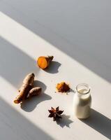 Turmeric, ginger, and milk on a white table photo